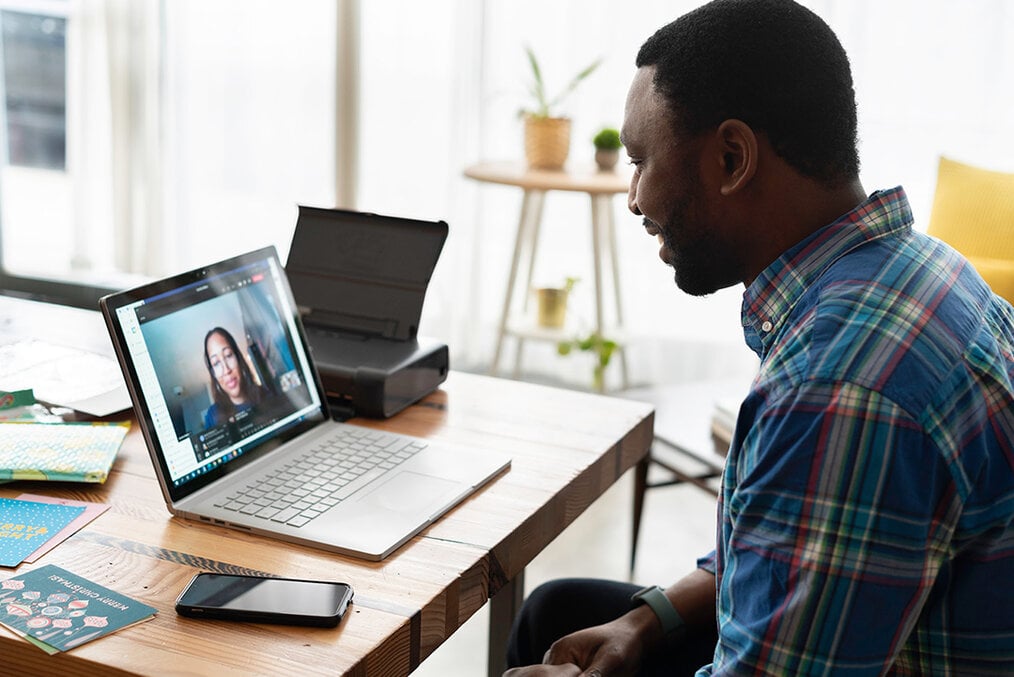 A person videoconferencing on their computer while at a desk