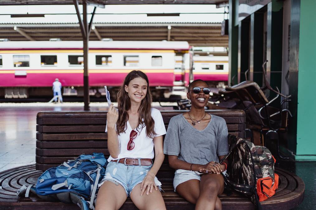 2 friends sitting at a train station