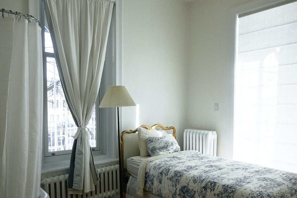 A small bed in the corner of a bedroom