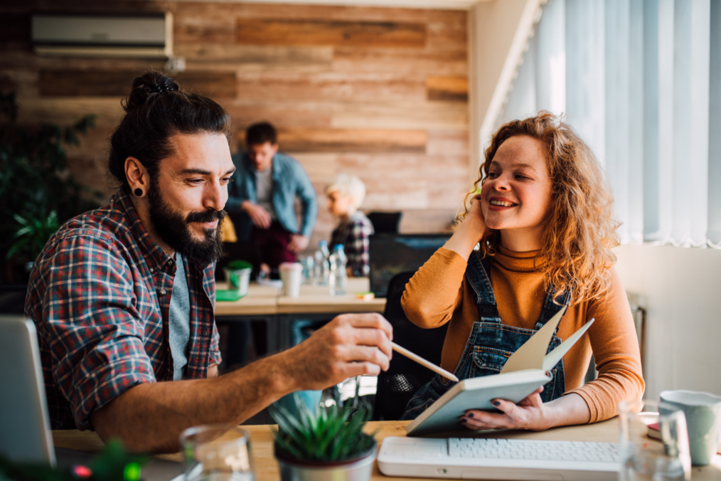 Why You Should Learn a Second Language A person with black long hair and a beard teaching someone with blonde wavy hair