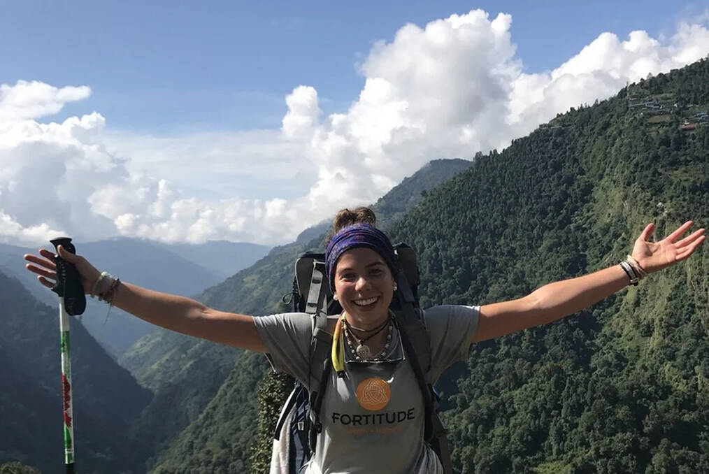 A hiker spreading their hands in joy
