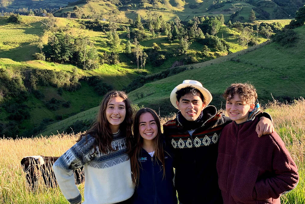 Four young adults standing in front of mountains in Ecuador