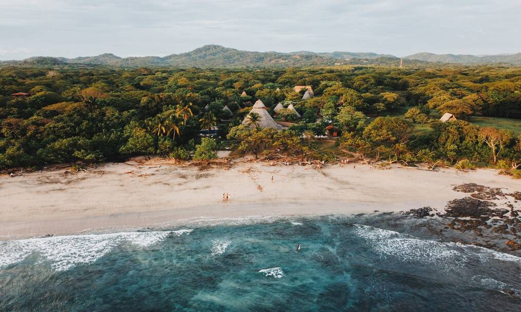 The coastline of Costa Rica with lush green forests and mountains in the background