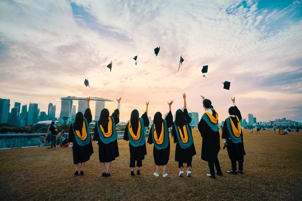 Photo by Pang Yuhao on Unsplash A group of students throw their graduation caps into the air.