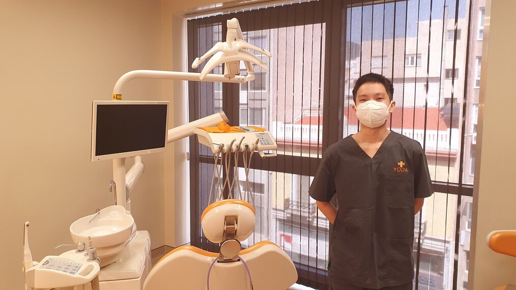 Jacob N. Cerca Abroad Dentist standing next to patient chair and dental equipment