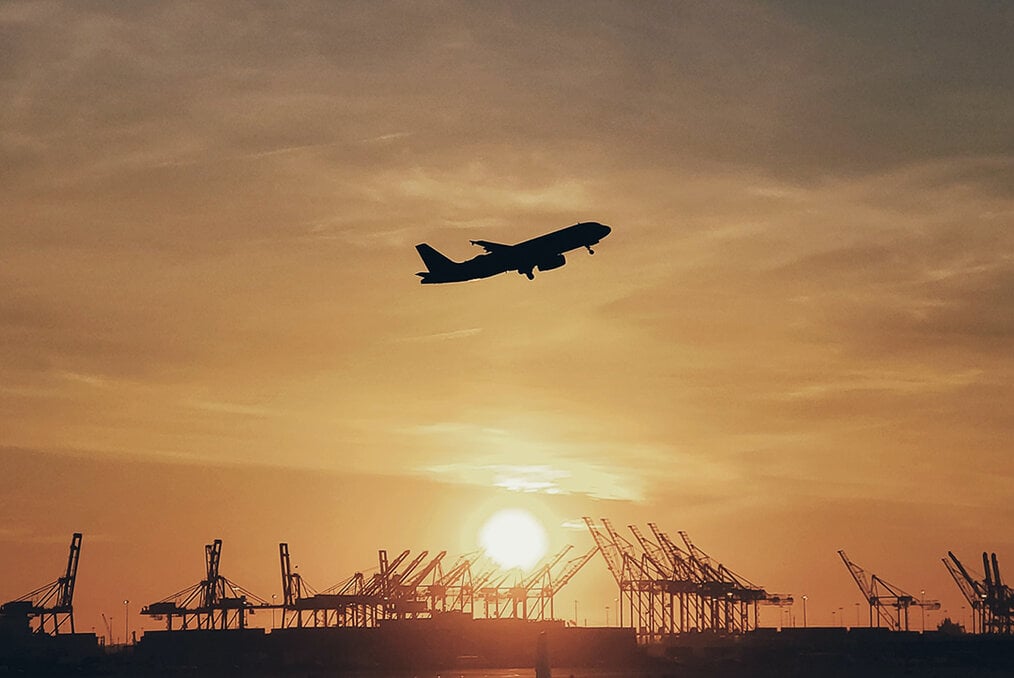 A plane ascending with a sunset in the background