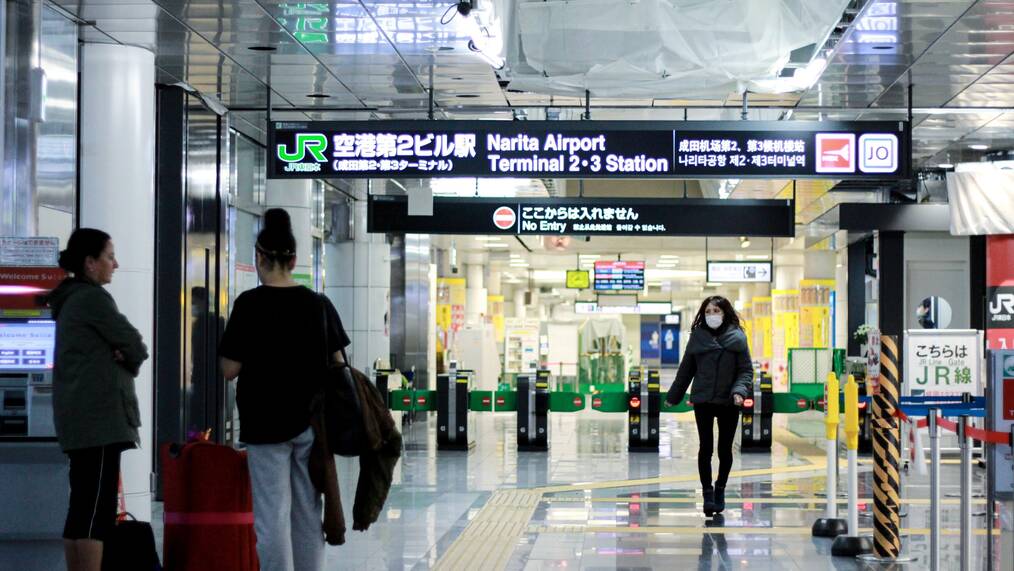 People walk through an airport terminal in Narita, Japan.