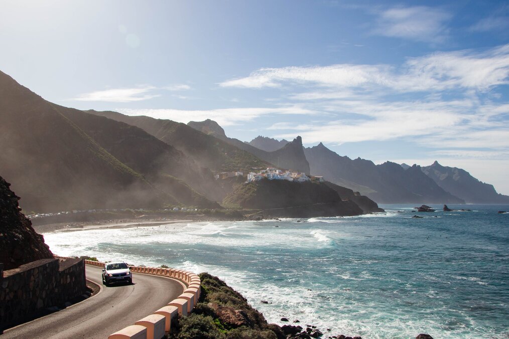Photo by Maria Lupan on Unsplash A car drives along a coastal highway in Tenerife, Spain.