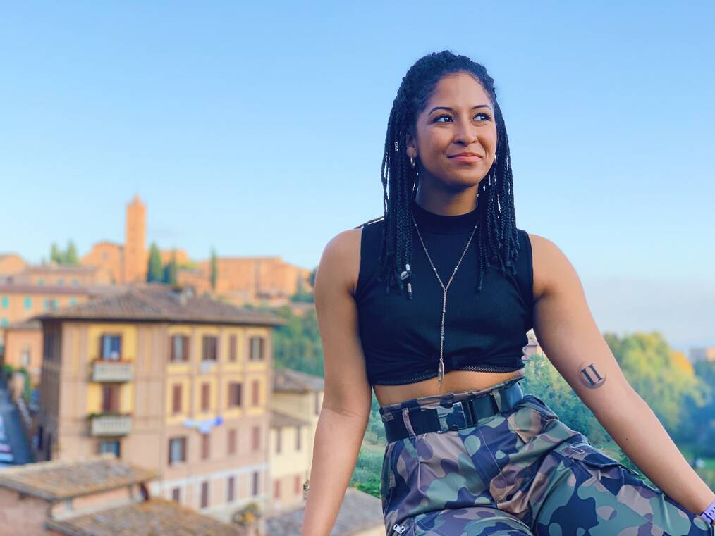 Girl sitting on ledge overlooking village