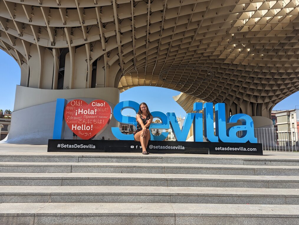 Olivia Cantalupo, CIEE, College Study Abroad in Seville, Spain alum Olivia Cantalupo sitting in front of the "I love Savilla" sign in Saveille