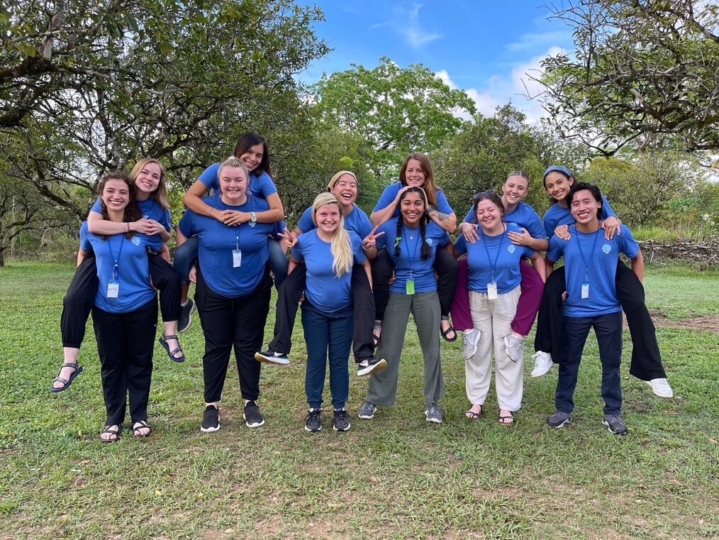 Kaylyn C., Therapy Abroad, Communication Sciences & Disorders in Belize alum Kaylyn C. in a group with Therapy Abroad study abroad students wearing blue shirts and smiling