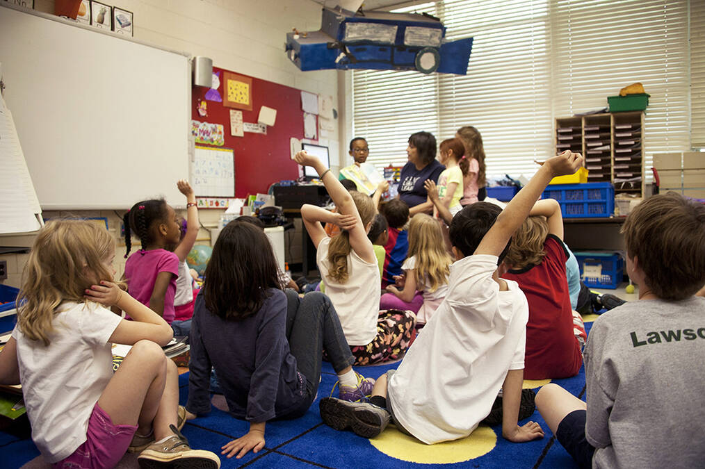 Students raising their hands in class