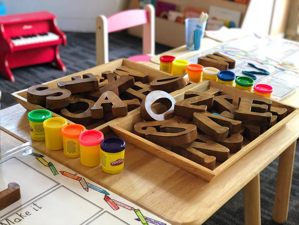 A desk with play-doe and block letters