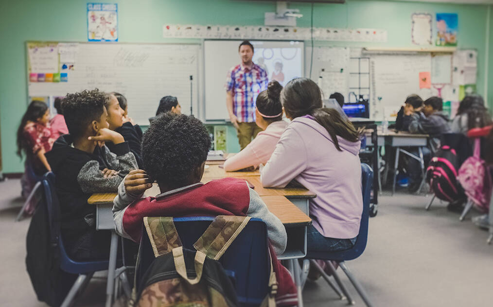 A classroom of kids listening to the teacher
