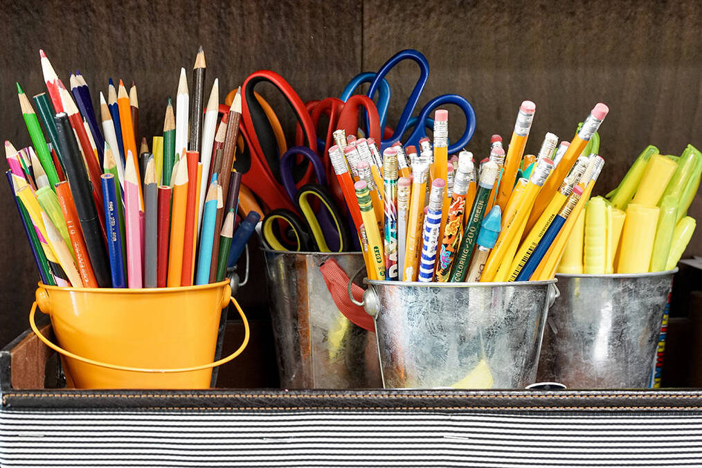 Colored pencils and scissors organized in tins