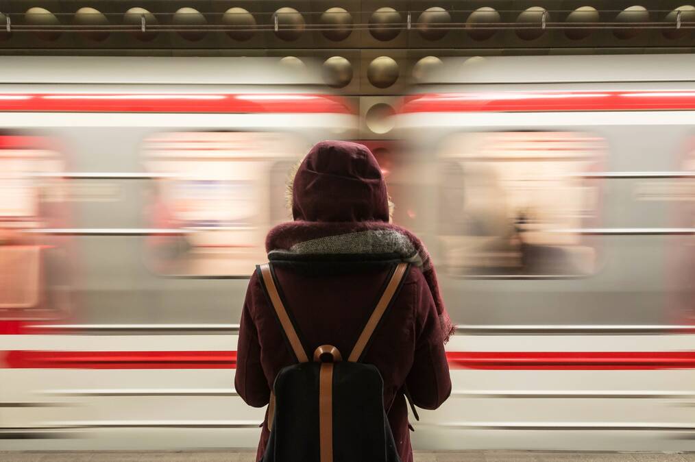 Person at train stop waiting for trains