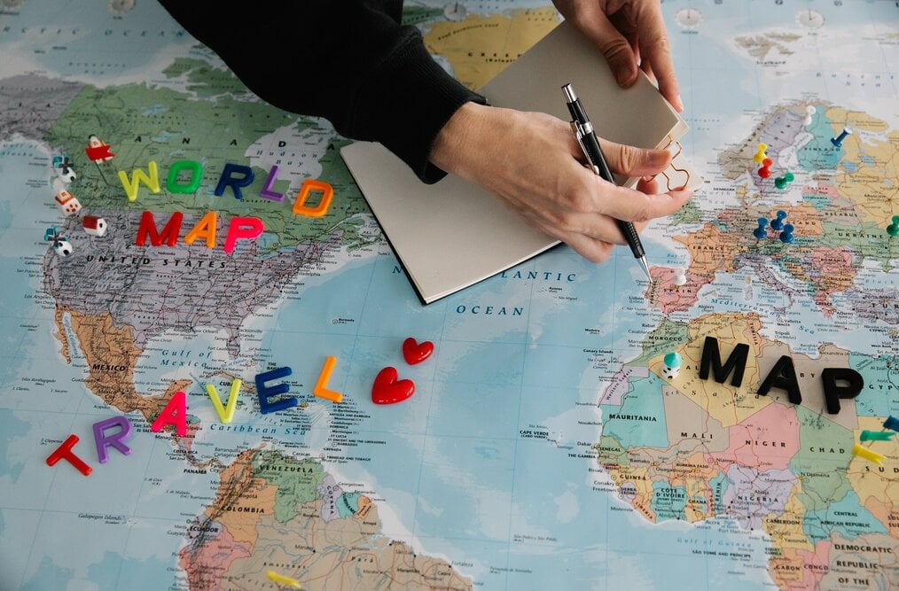 Person writing notes and looking at map