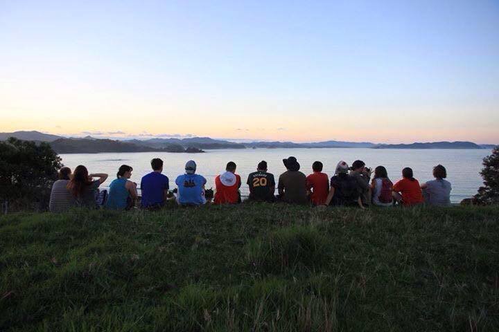 Nicholas Boulos, Pacific Discovery alum Nicholas Boulos sitting with a group on the top of a mountain with clouds