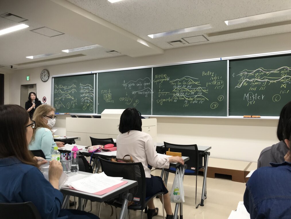 Soichiro Nishisako, Teach Away A teacher stands at the front of a classroom with adult students.
