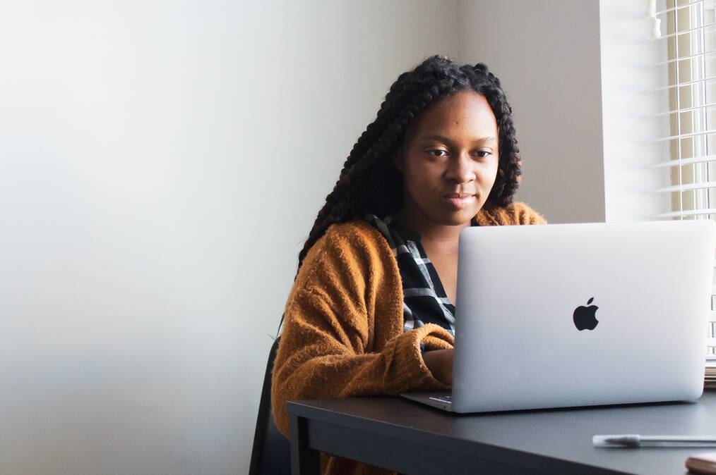 A woman looks at a laptop screen.