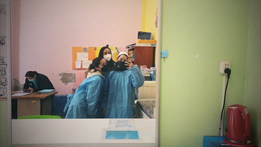 3 Volunteers in medical ponchos taking a photo