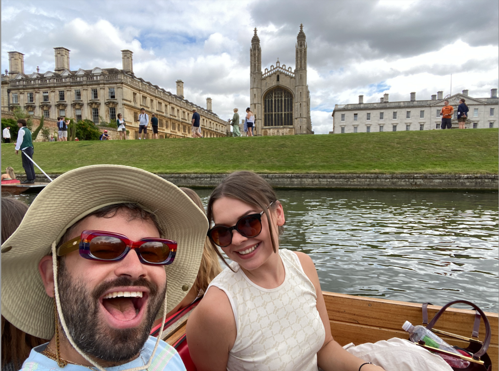A man and woman smile at the camera while on a boat in Cambridge, England.