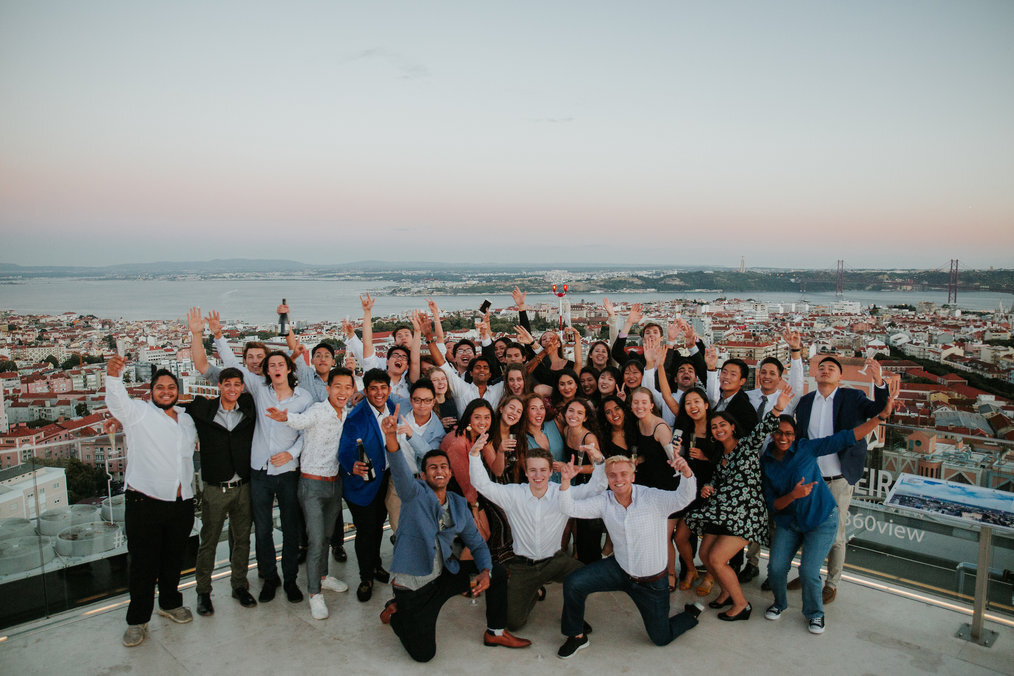 iXp A large group of people pose smiling with their arms in the arm.