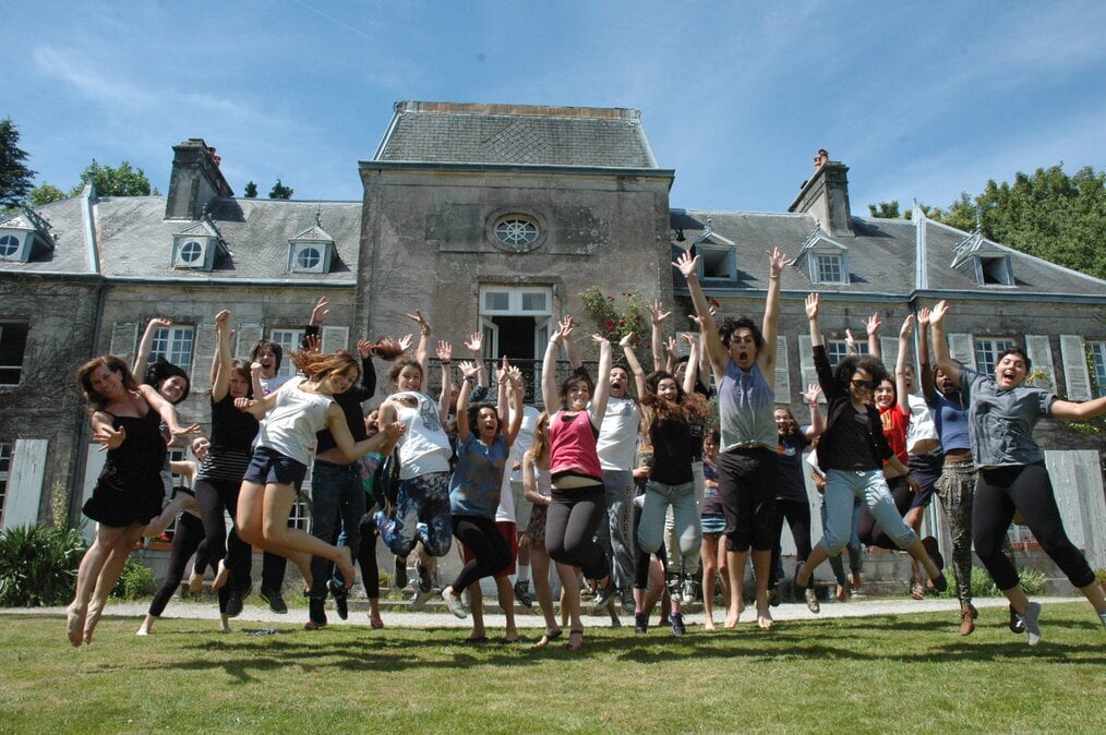 BP semester A group of students jump in the air in front of a history French manor.