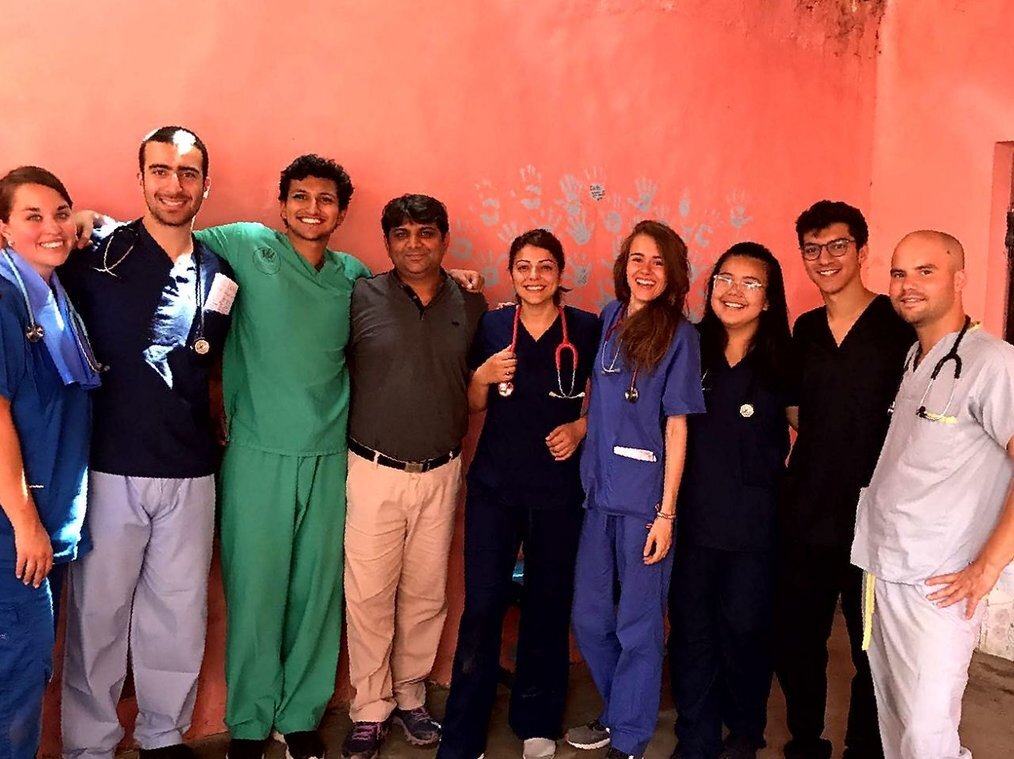 IVHQ A group of healthcare volunteers wearing scrubs stand and smile.