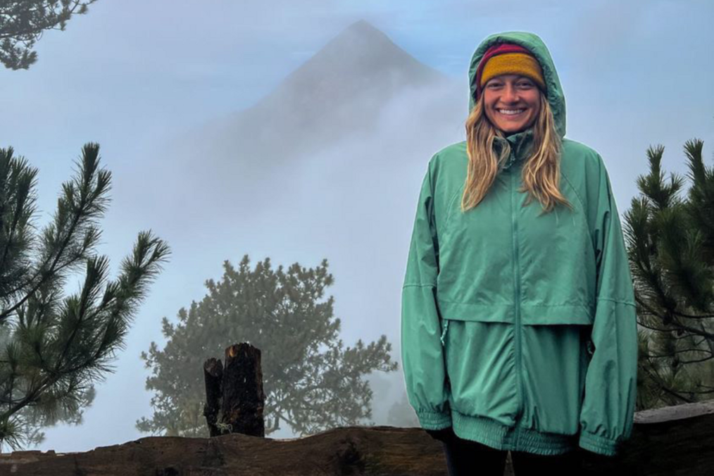 Volunteer smiling in front of volcano