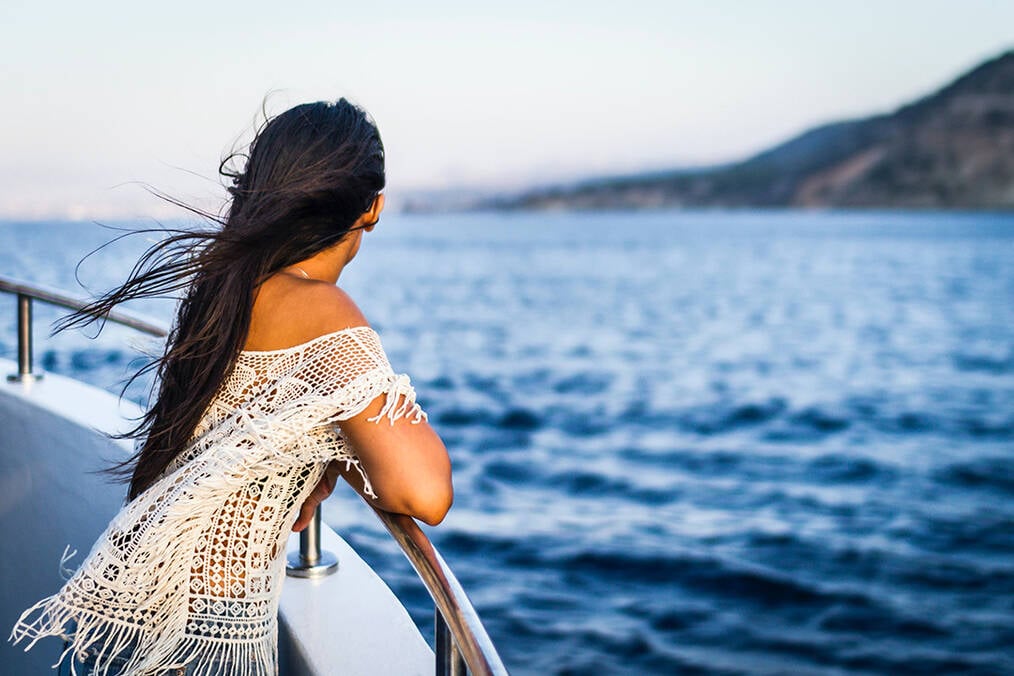 A girl on a ship looking off into the distance