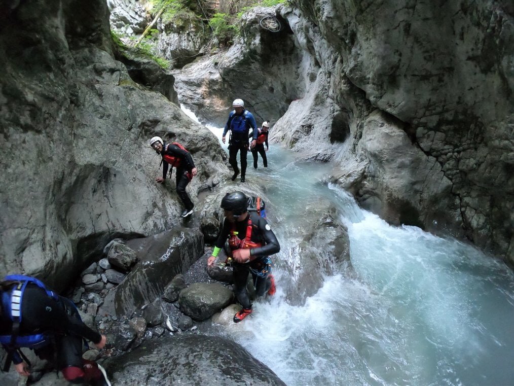 Travel for teens People walk through a cave as water rushes by.