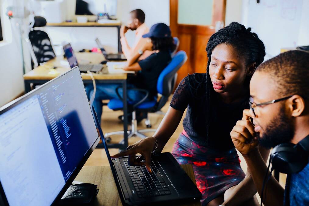 Two people look at a computer screen.