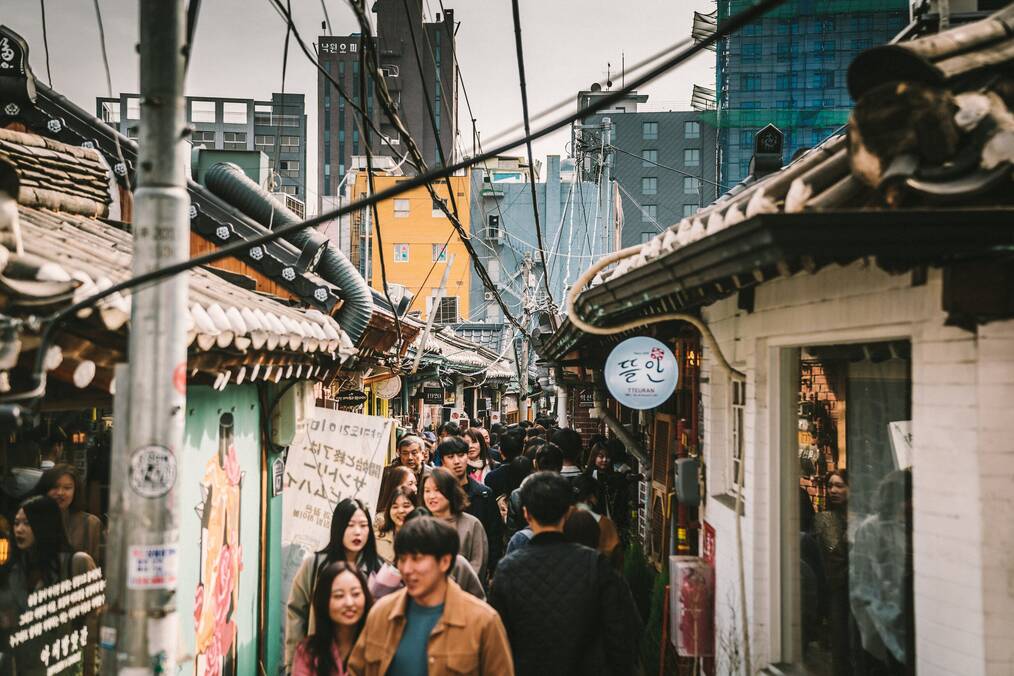 People walk down a narrow alley in Korea.