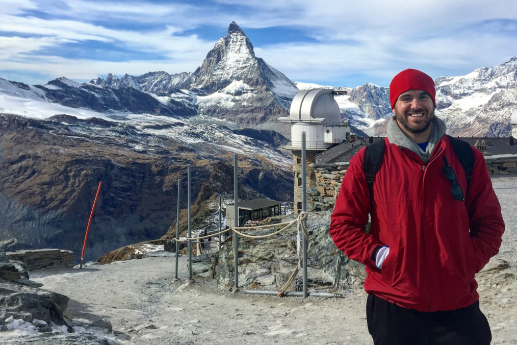 Traveler smiling in front of snowy mountains