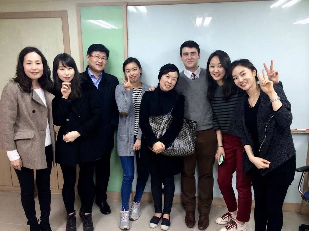 A group of people stand together and smile for the camera.