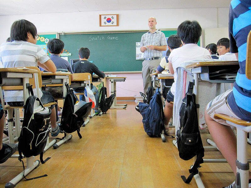 A teacher stands at the front of the classroom in South Korea.