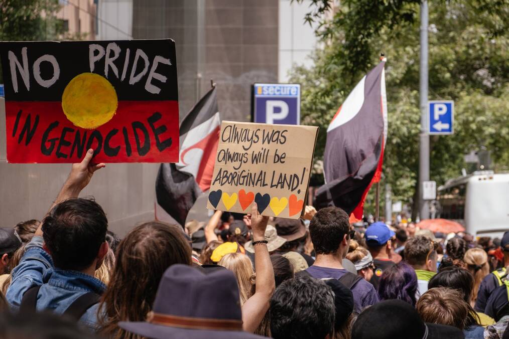 People protest and hold signs in Melbourne.