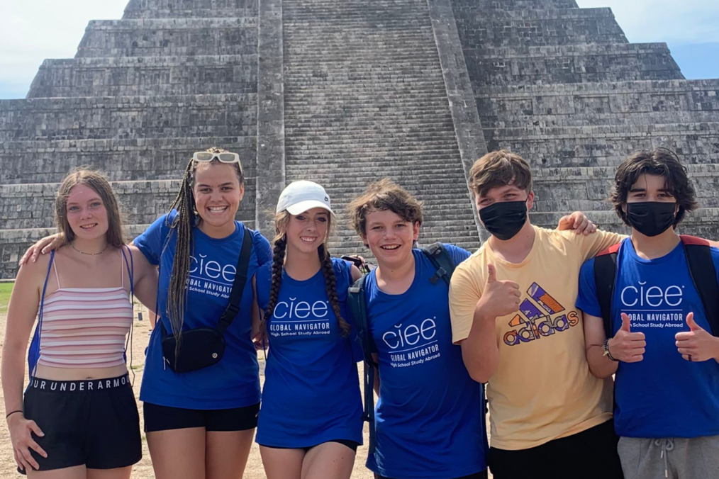 Group of travelers smiling in front of a temple