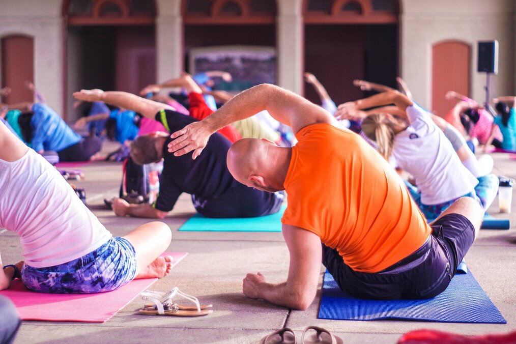 Photo by Anupam Mahapatra on Unsplash People stretch on mats on the floor.