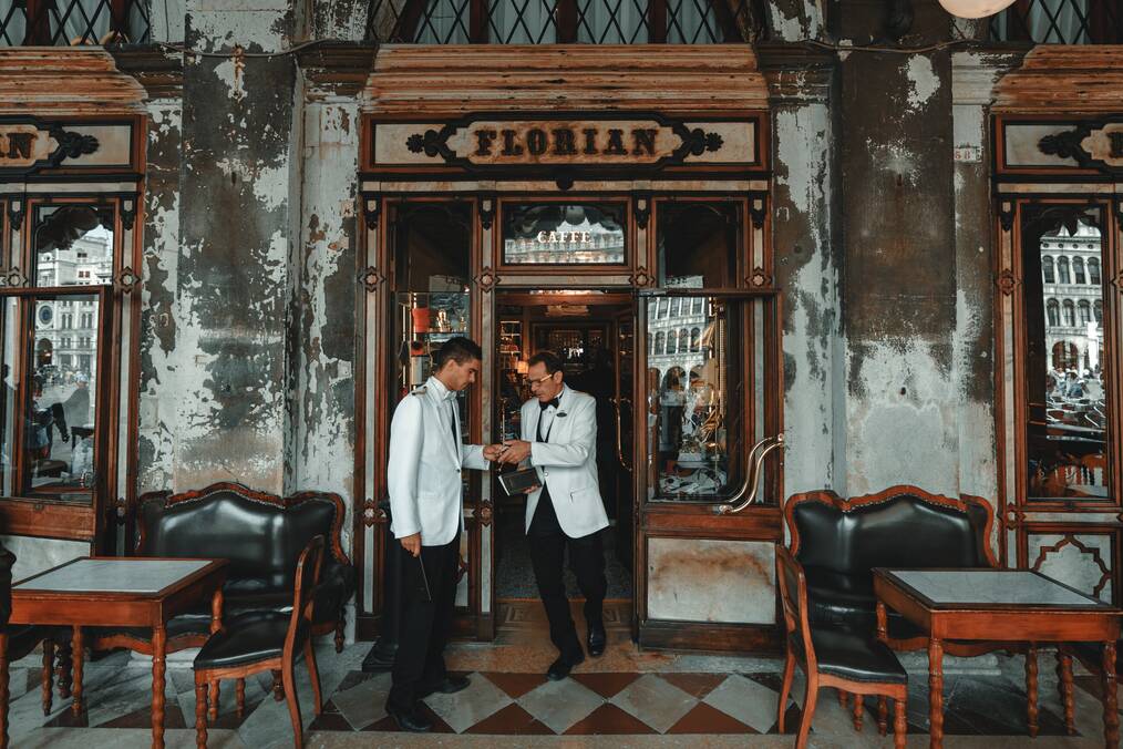 Two men in uniforms stand outside a restaurant.