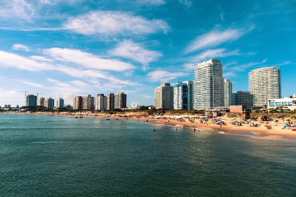 High rise buildings line a white sand beach.