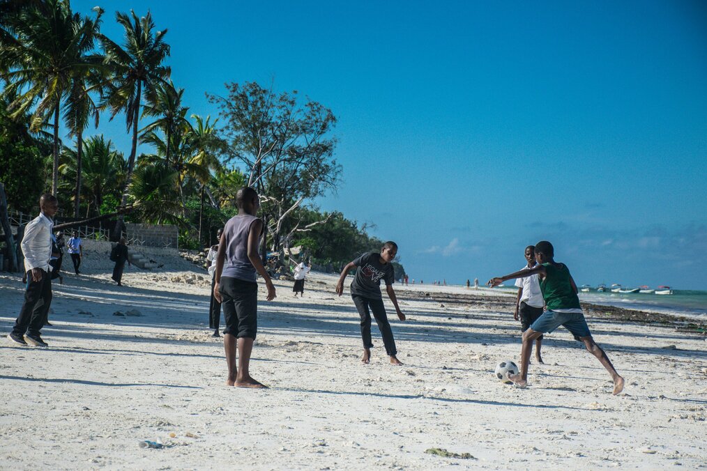 Group of kids playing with soccer ball on teach 