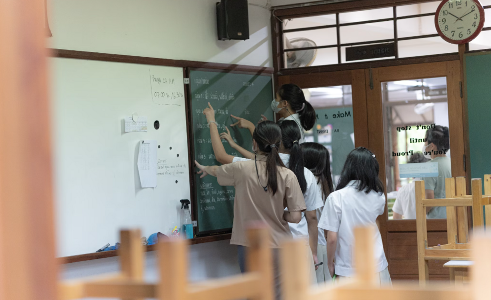 Students writing on a whiteboard in Thailand 