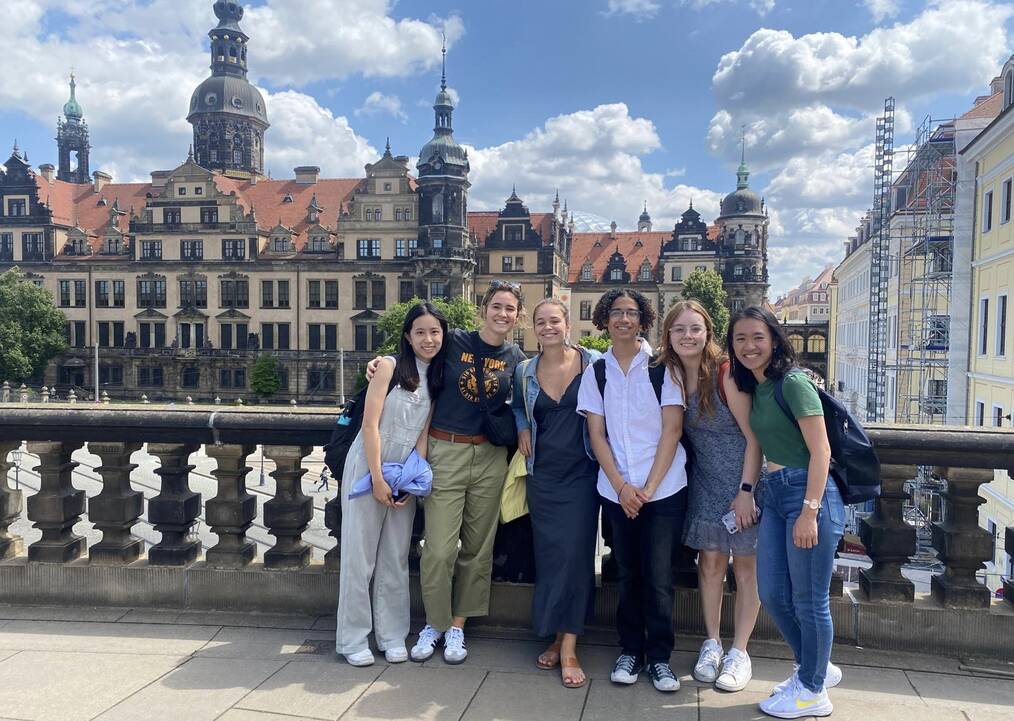 A group stands smiling in front of an ornate building in Germany.