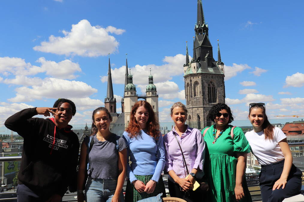 A group of people smile in front of a castle.