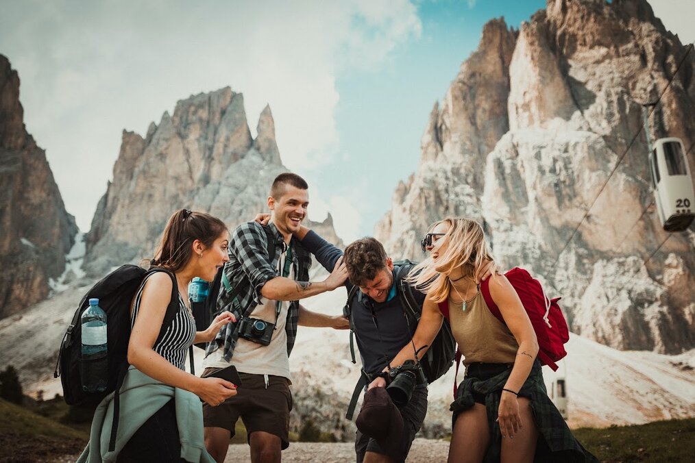 Friends laughing atop mountains