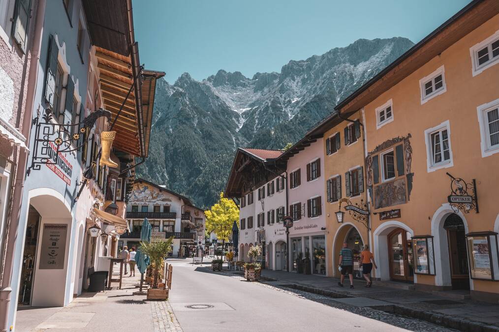 Mountains loom behind a street with storefronts.