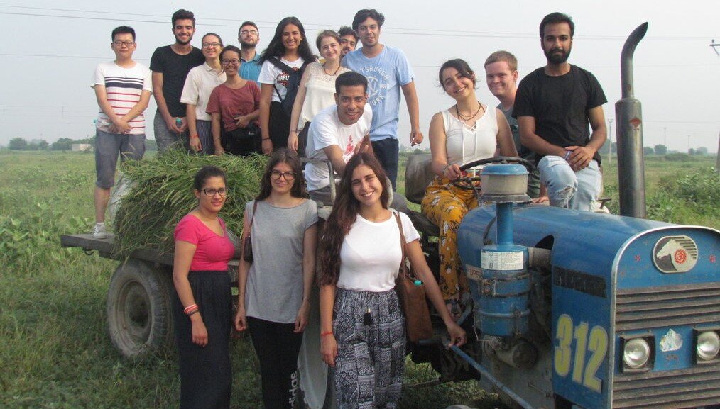 TTW A group of young people pose smiling on a tractor in India.
