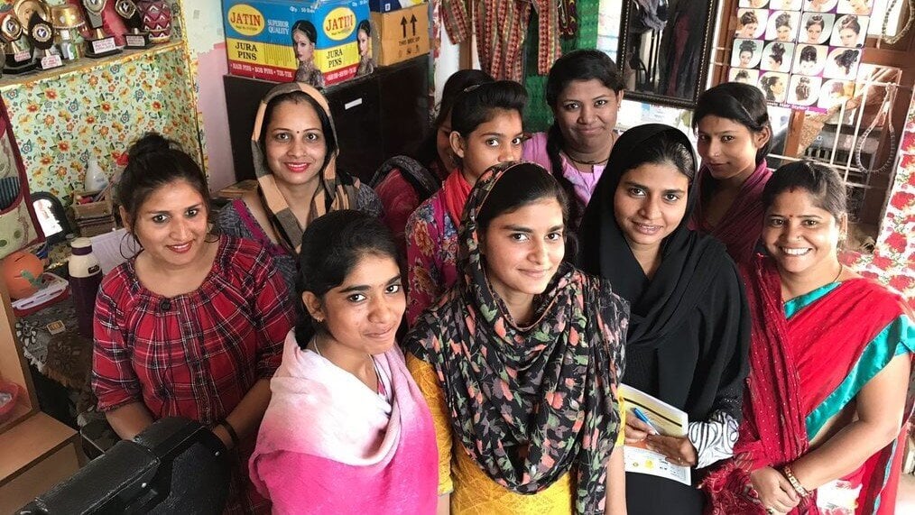 Women Empowerment Program India A group of women stand and smile.